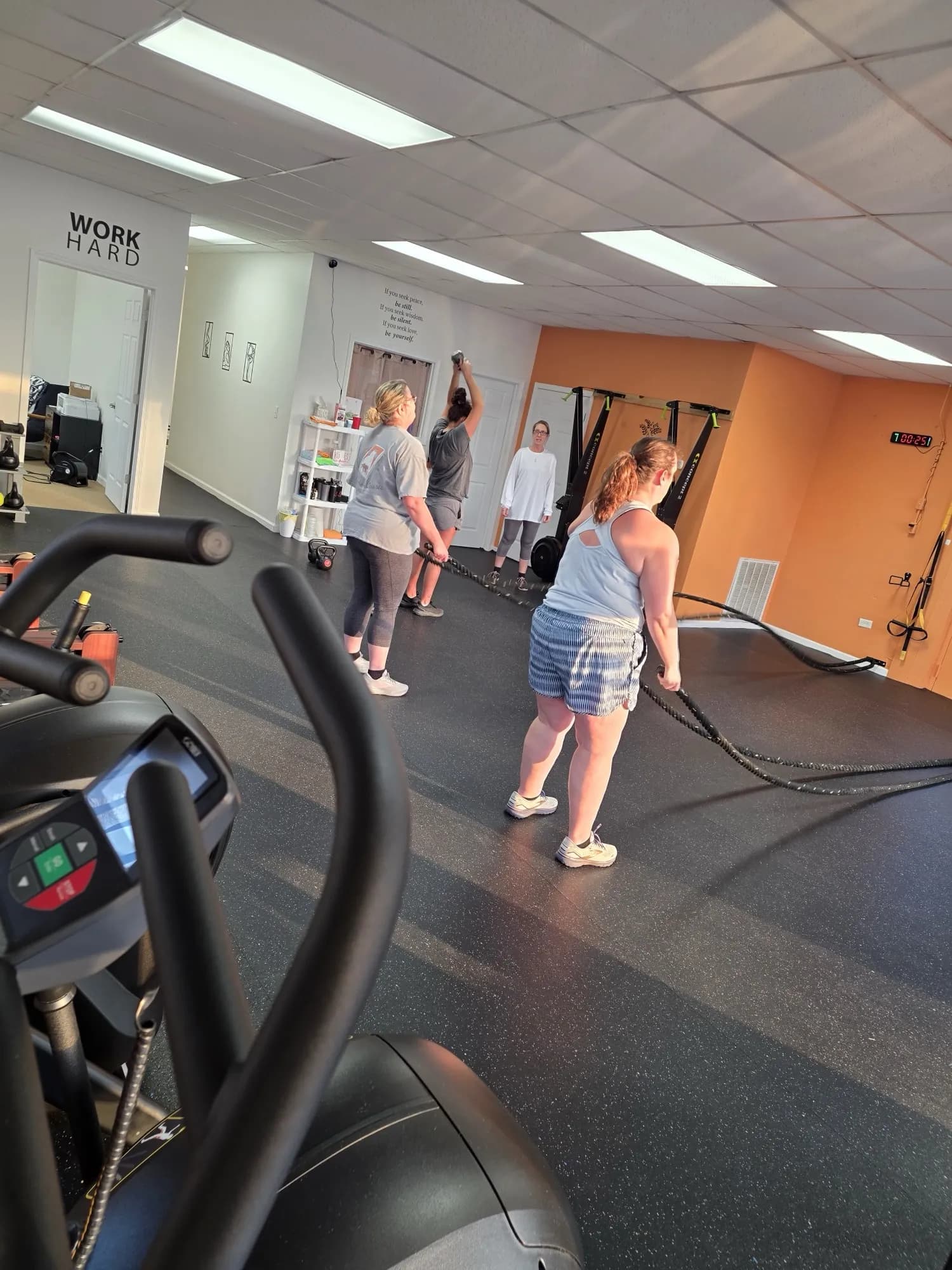 Members training with battle ropes during a group fitness class