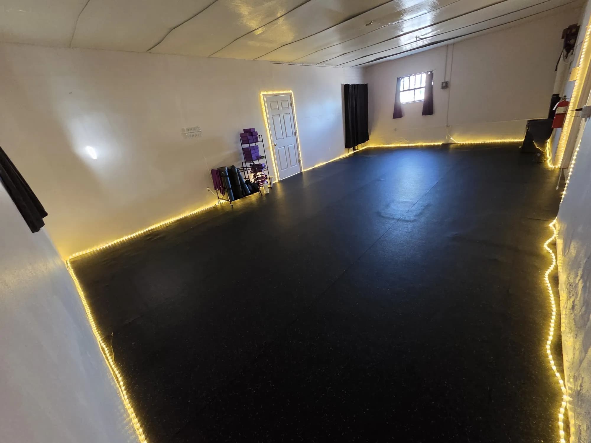 The yoga room at VivaHealth Studio, lined with warm lights
